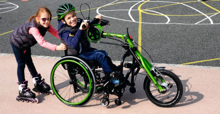 child with disabilities in a hand bike